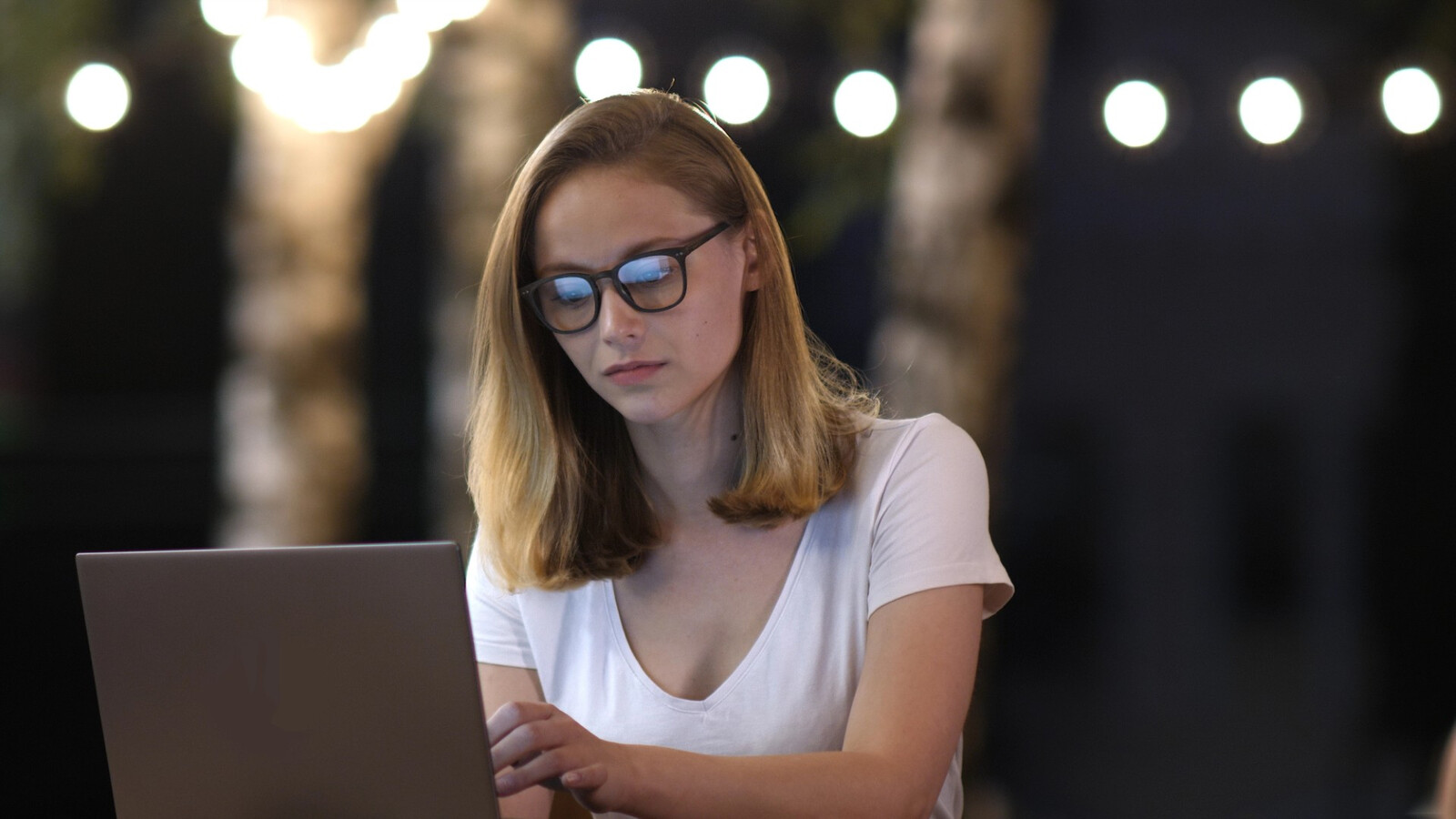 Woman wearing glasses operating a laptop