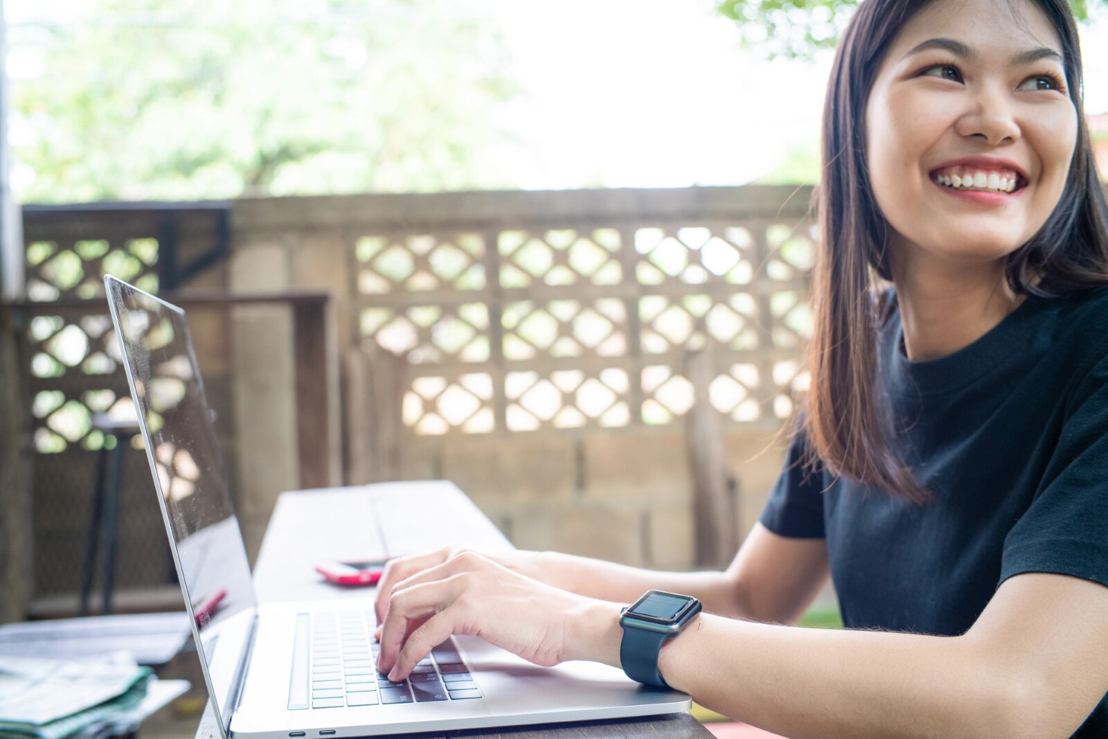 Person looking away from a laptop while their hands are at the keyboard